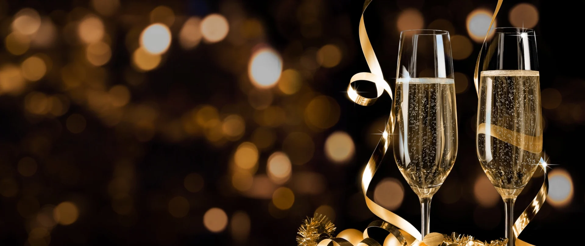 Sektgläser vor goldenen Lichtern